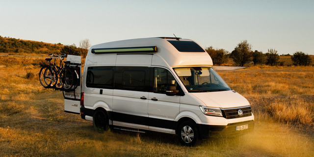 Ein Camper ist im Sommer auf einem Feld geparkt