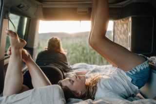 Child lying with his feet up in the camper while camping in Holland by the sea